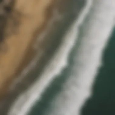 Aerial view of surfers catching waves at a sunny California beach