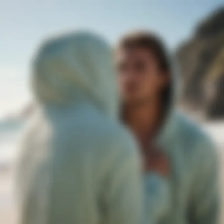 Surfer in a towel hoodie by the ocean