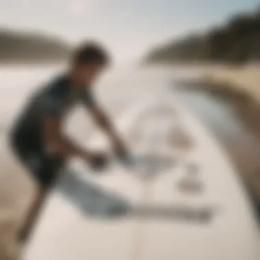 Surfer applying a sticker to their board at the beach