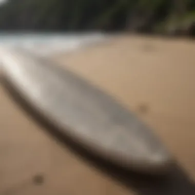 Close-up of a surfboard with intricate designs on the beach