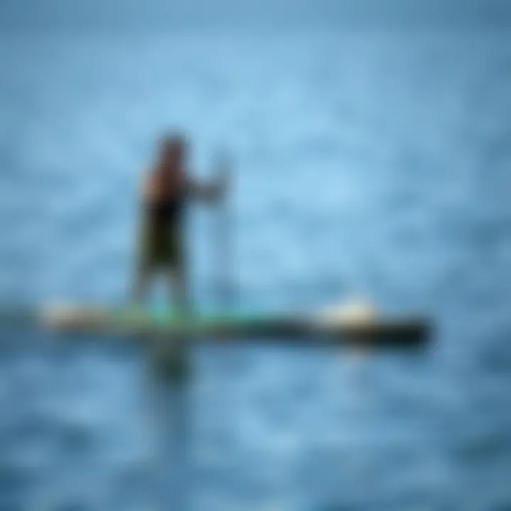 An individual standing on a paddle board in calm waters, demonstrating stability