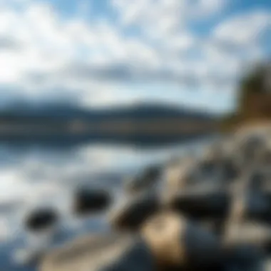 A Tranquil Spot for Skipping Rocks A serene lake reflecting the sky with perfectly smooth stones along the shore