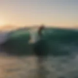 Surfer riding a wave at Todos Santos during sunset