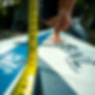 Close-up of a paddle board measuring its length against a measuring tape.